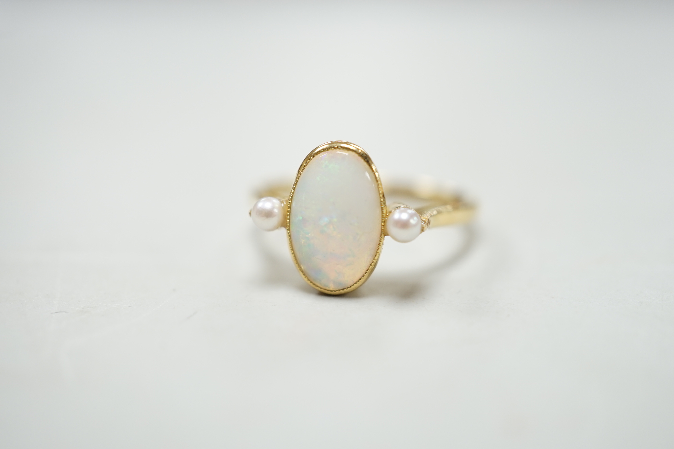 An 18ct, white opal and cultured pearl set three stone ring, size M, gross weight 3.1 grams.